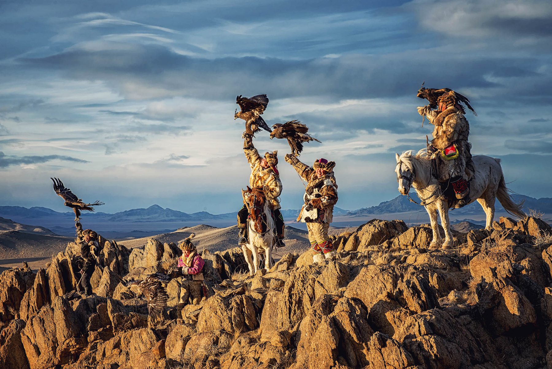 Kazakh eagle hunters on a ridge in Bayan-Ulgii